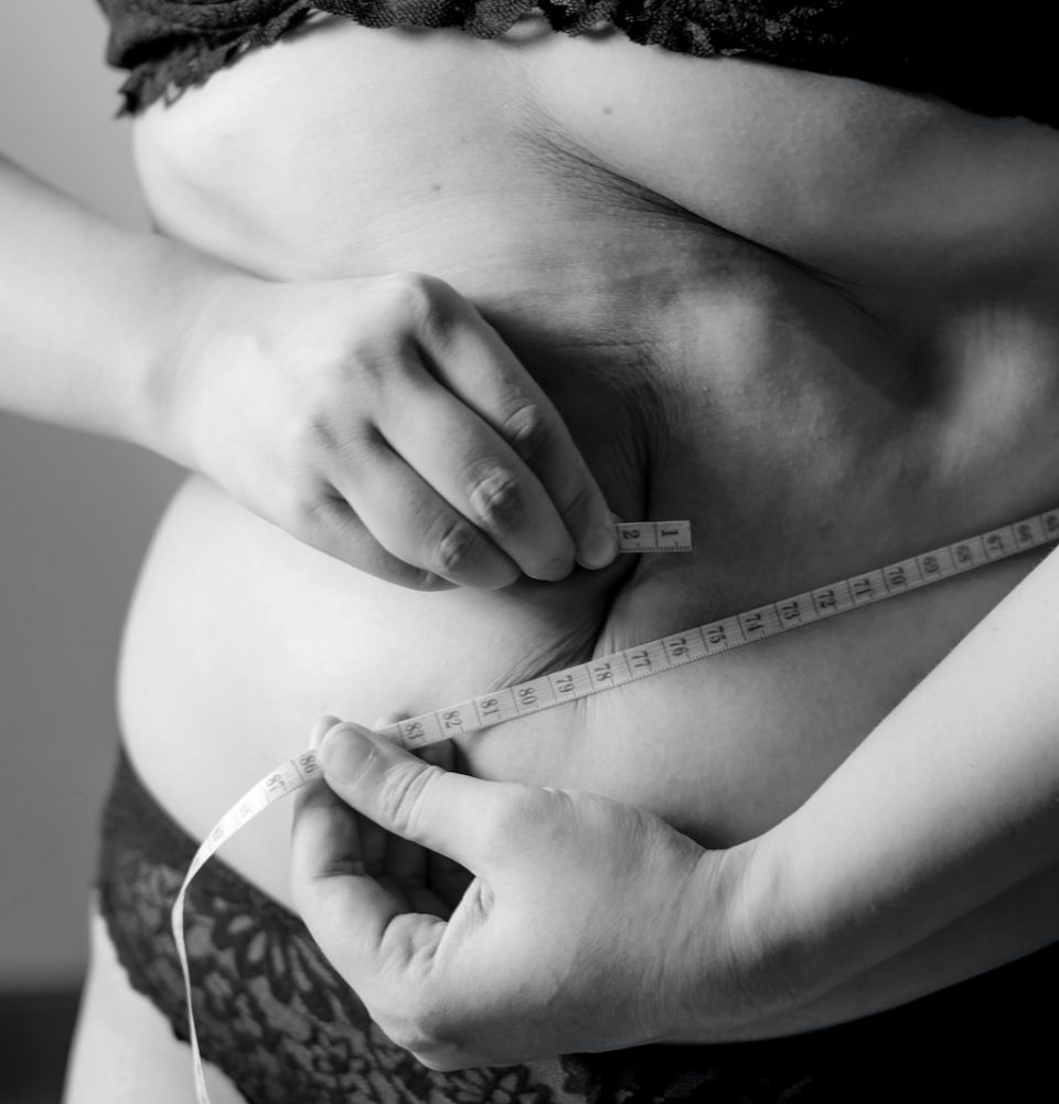 grayscale photo of woman holding her breast