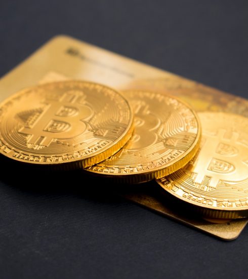three round gold-colored Bitcoin tokens