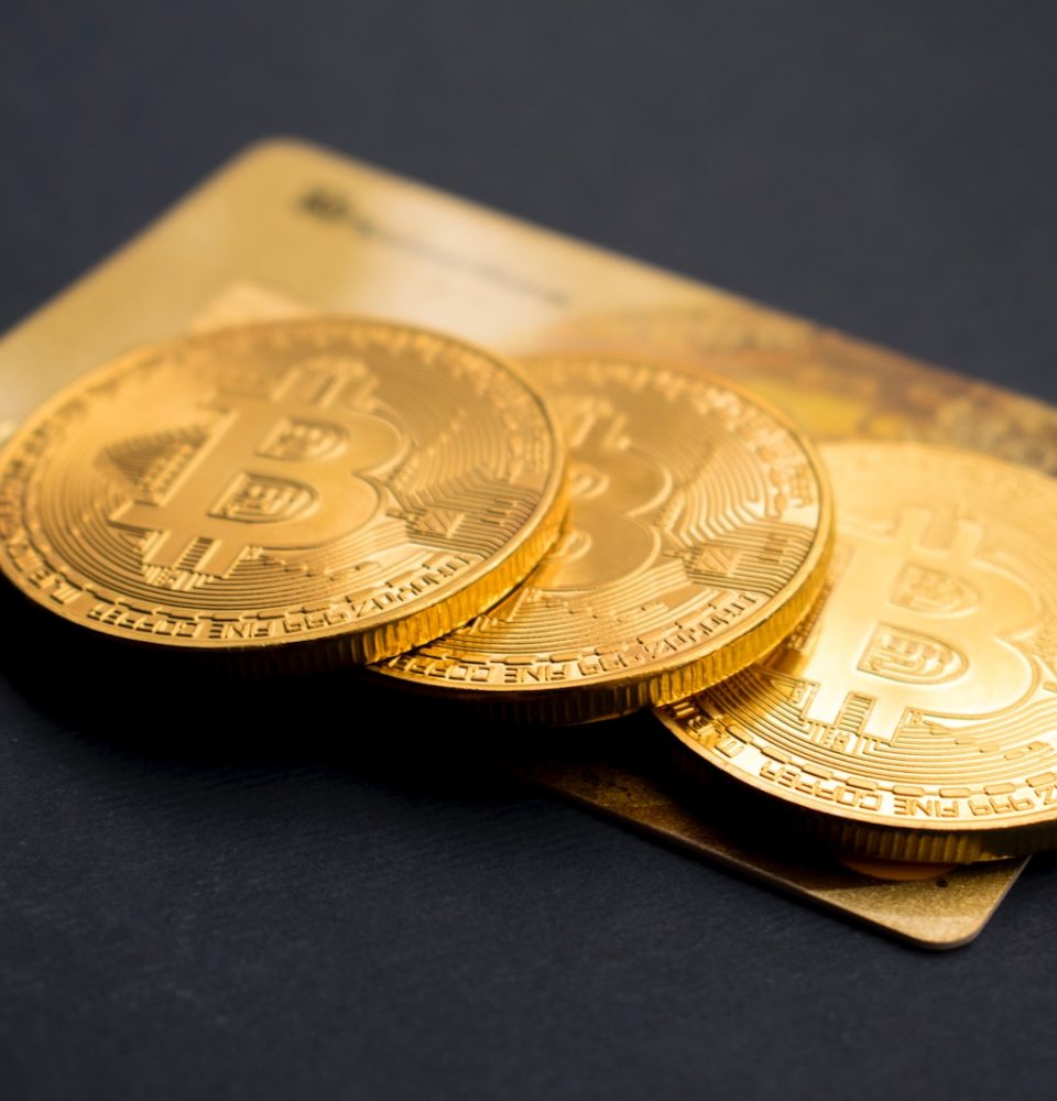 three round gold-colored Bitcoin tokens