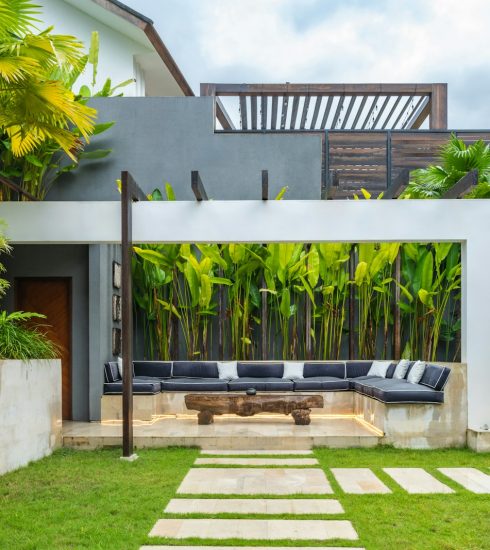 A backyard with a stone path leading to a covered patio